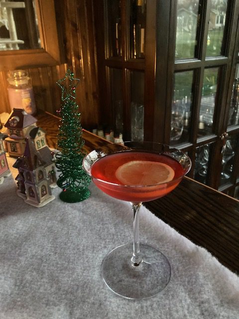 Billionaire Riff: Red cocktail in a coupe glass topped with a thin lemon slice.