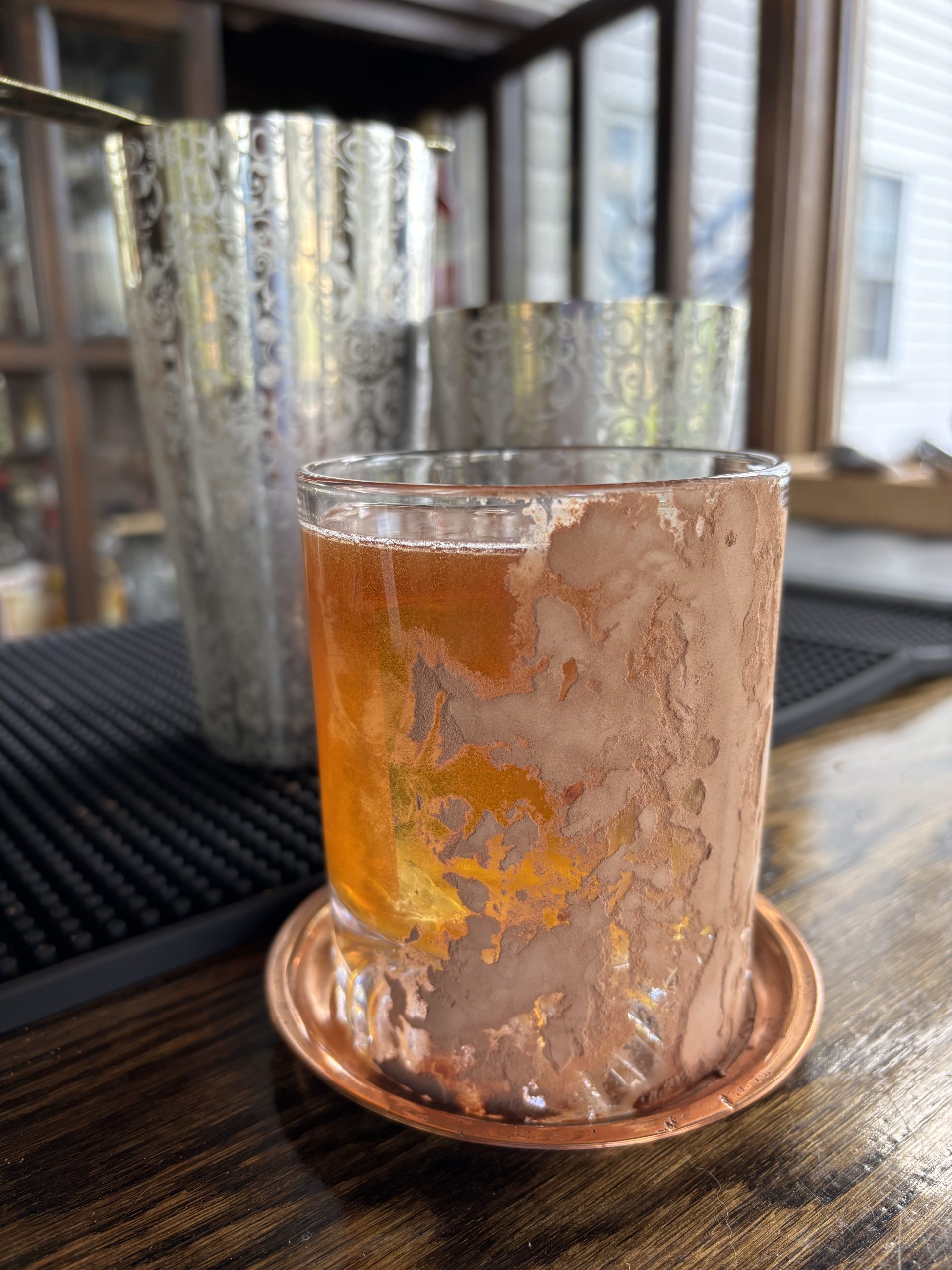Rum Old Fashioned: Golden beverage in a cacao-crusted old fashioned glass.