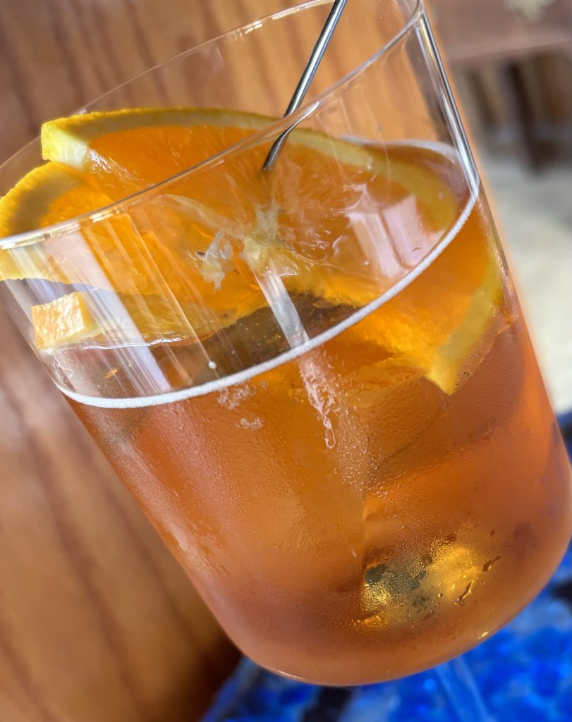 Orange Amaretto Sidecar: Layers of sliced orange in pinwheel arrangement over a pale orange cocktail