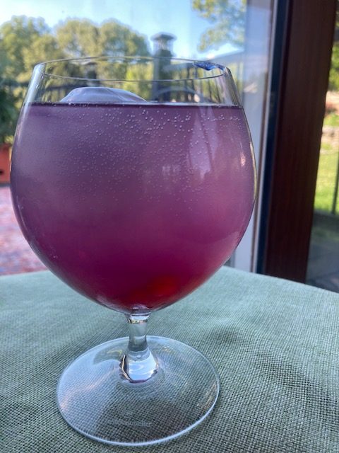 Butterfly Pea Flower Gimlet with Strawberry Boba: Purple cocktail in a goblet with pink boba and an ice sphere.